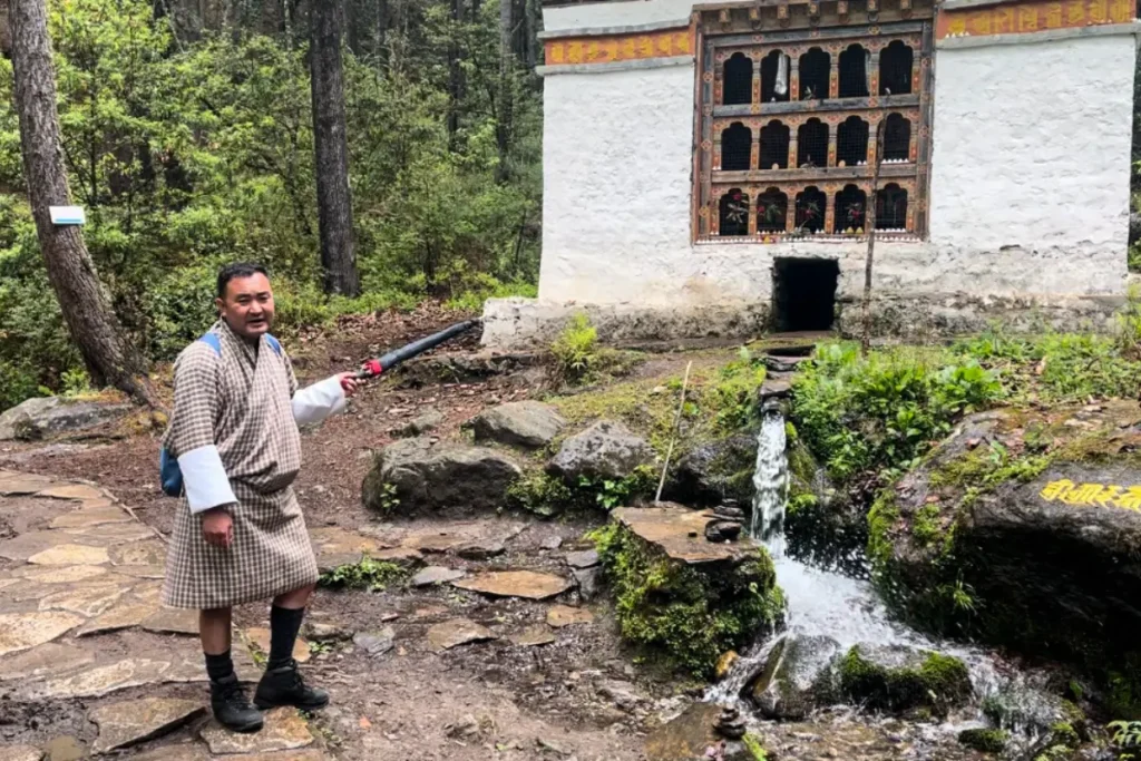 Water-powered prayer wheel on Tiger’s Nest Monastery trek in Bhutan, explained by local guide.